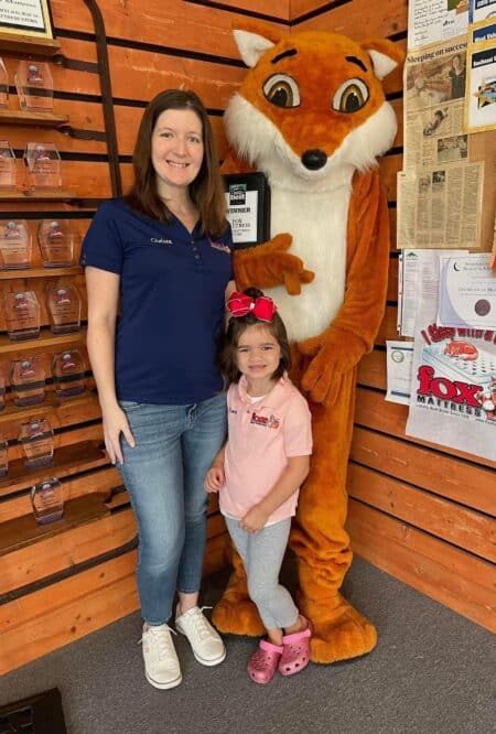 Woman and child with Fox mascot at Mattress Underground event promoting healthy sleep and mattress education.