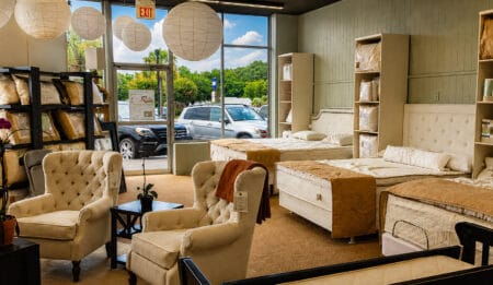 Interior of Seeping Organic showroom displaying organic mattresses, beds, and cozy seating area with large windows and natural light.